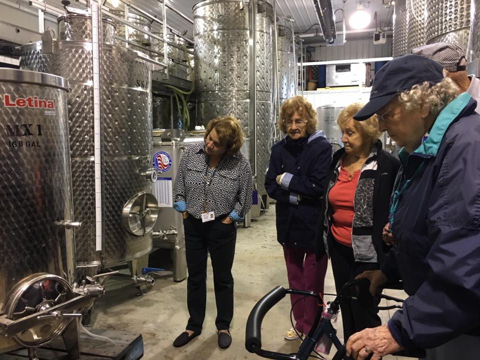 Conneaut Cellars Winery Visitors shown touring through the wine aging room.