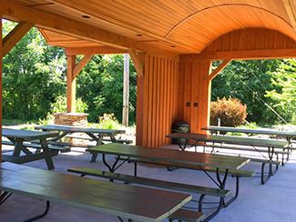 Interior image of the Conneaut Cellars Picnic Pavilion showing woodwork details and picnic tables.
